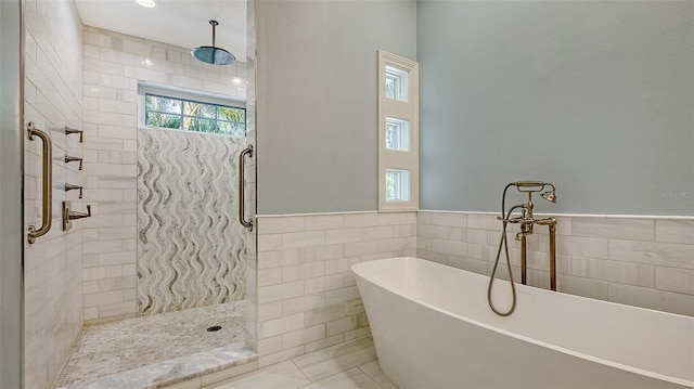 bathroom with separate shower and tub and tile walls