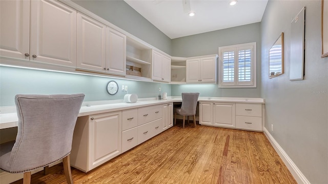 office with built in desk and light wood-type flooring