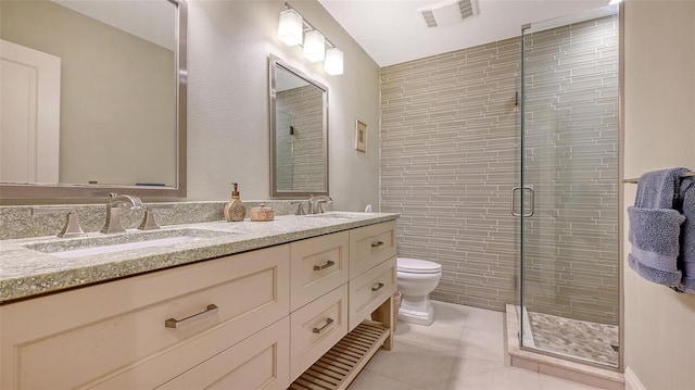 bathroom with vanity, a shower with door, tile patterned floors, and toilet