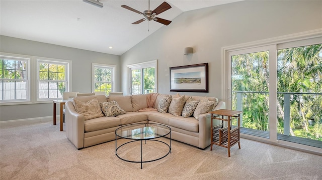 carpeted living room with ceiling fan, a wealth of natural light, and high vaulted ceiling