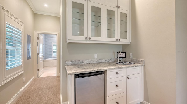 bar featuring sink, crown molding, white cabinetry, light stone countertops, and light colored carpet