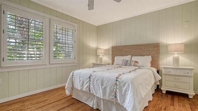 bedroom featuring ceiling fan, ornamental molding, and light wood-type flooring