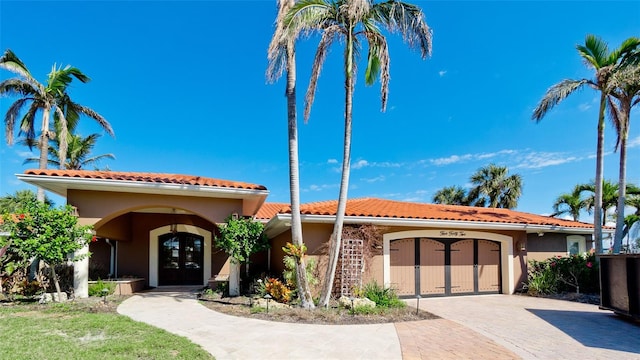 mediterranean / spanish home featuring french doors and a garage