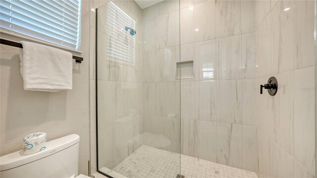 bathroom featuring an enclosed shower and toilet