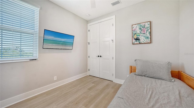 bedroom featuring ceiling fan, light wood-type flooring, and a closet