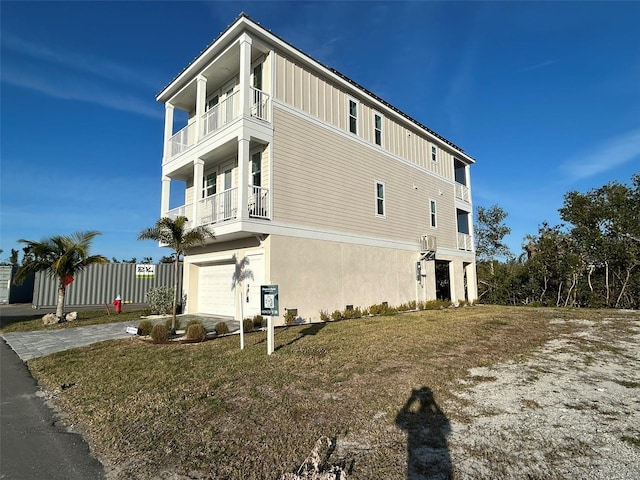 view of home's exterior featuring a yard, a garage, and a balcony