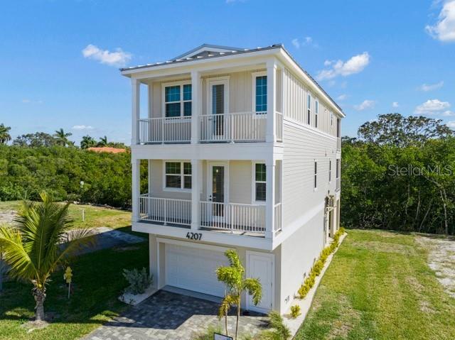 view of front of home with board and batten siding, a garage, a front lawn, and a balcony