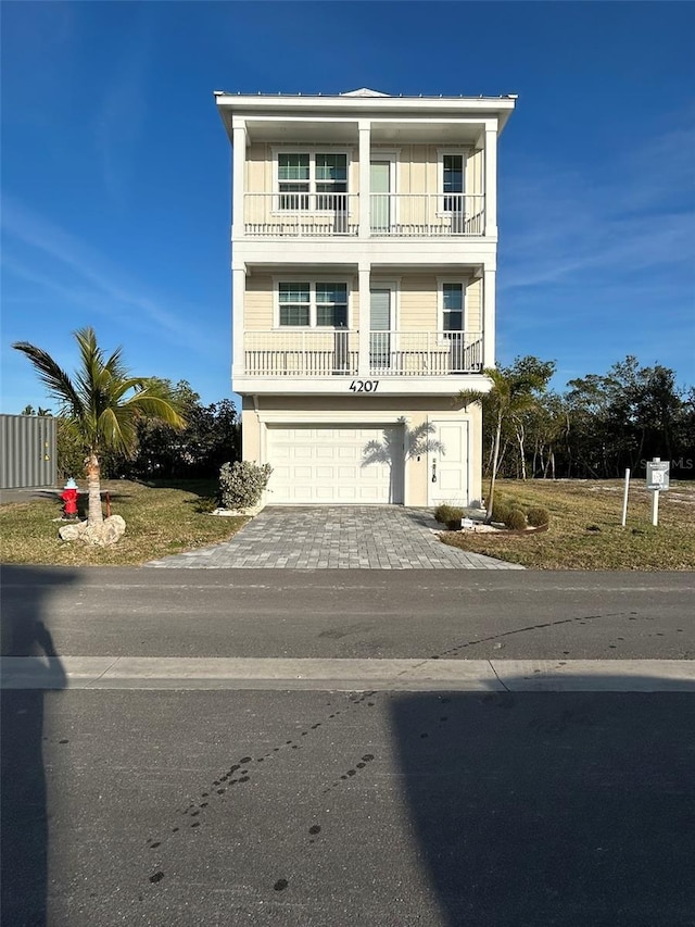 view of front of property featuring a balcony, driveway, and a garage