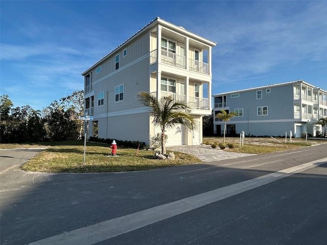exterior space with driveway, a garage, and a balcony