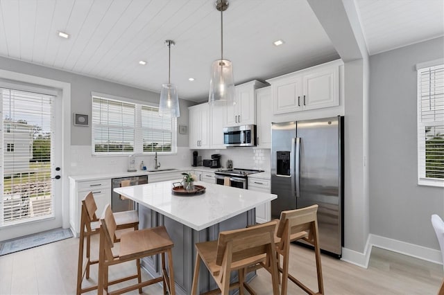 4207 Marina View Way, Cortez, FL 34215 - kitchen with appliances with stainless steel finishes, decorative backsplash, a breakfast bar, light wood-style floors, and plenty of natural light