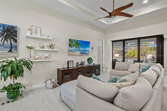 living room featuring a raised ceiling and ceiling fan