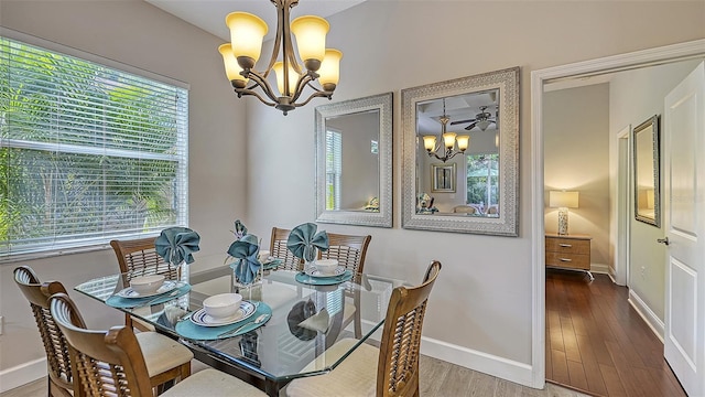 dining room featuring wood-type flooring and an inviting chandelier