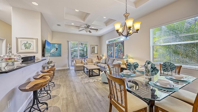 dining space with coffered ceiling, beam ceiling, ceiling fan with notable chandelier, and light hardwood / wood-style floors