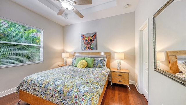 bedroom with dark hardwood / wood-style floors and ceiling fan