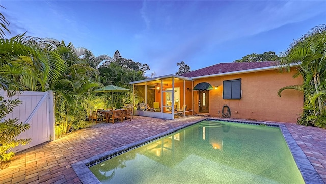 view of pool featuring a sunroom and a patio