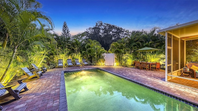 pool at dusk featuring a patio area