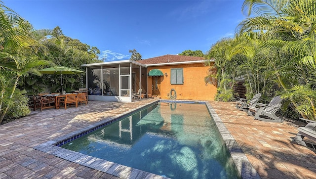 rear view of house with a patio area and a sunroom