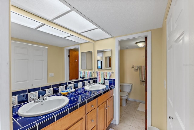 bathroom featuring vanity, backsplash, and toilet