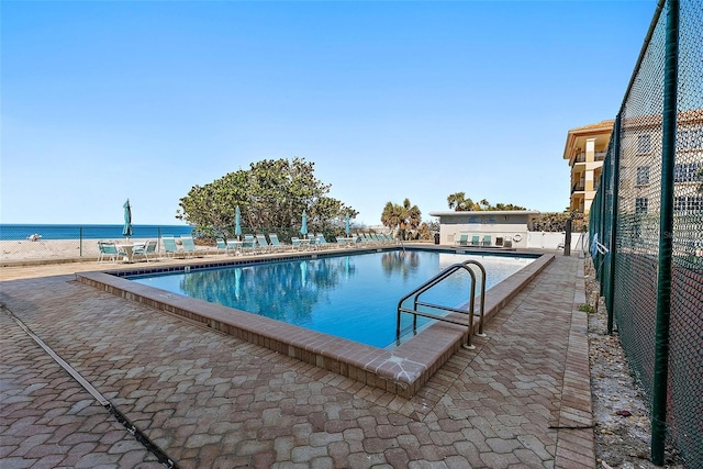 view of pool with a patio and a water view