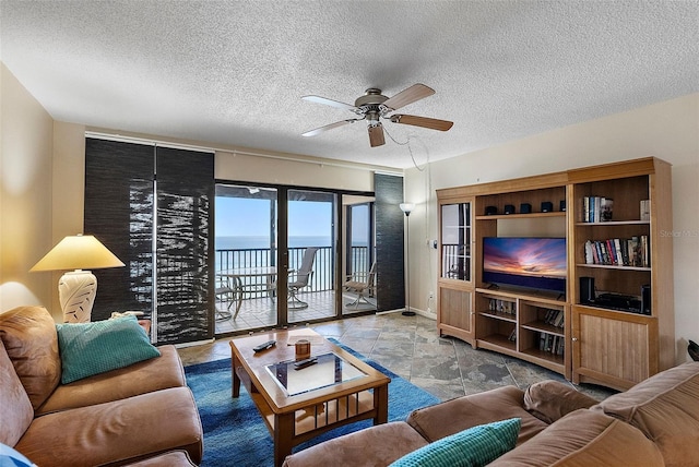 living room with ceiling fan and a textured ceiling
