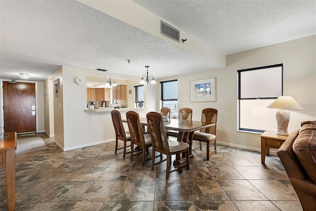 dining room with baseboards, visible vents, an inviting chandelier, and a textured ceiling
