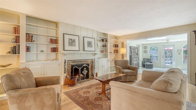 living room featuring built in features and light hardwood / wood-style floors