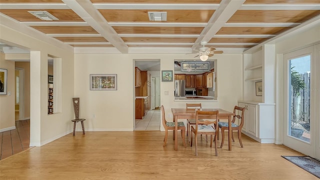 dining area with beamed ceiling, coffered ceiling, ceiling fan, and light hardwood / wood-style flooring