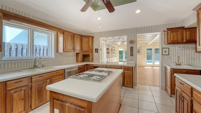 kitchen featuring sink, light tile patterned floors, a center island, and appliances with stainless steel finishes