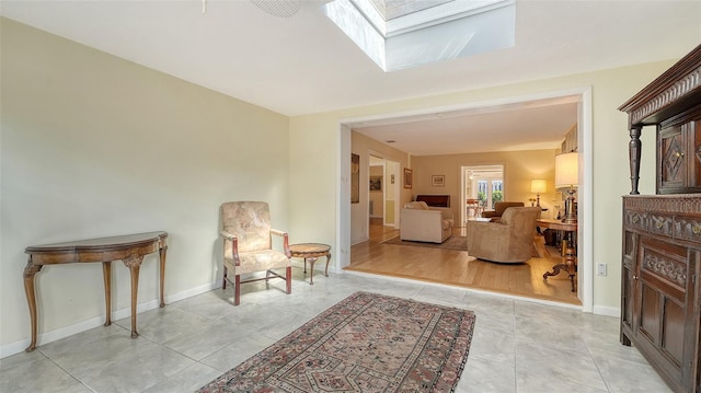 living area featuring light tile patterned flooring and a skylight