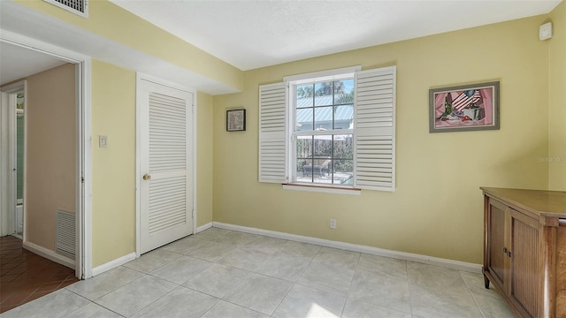 unfurnished bedroom with light tile patterned floors and a closet