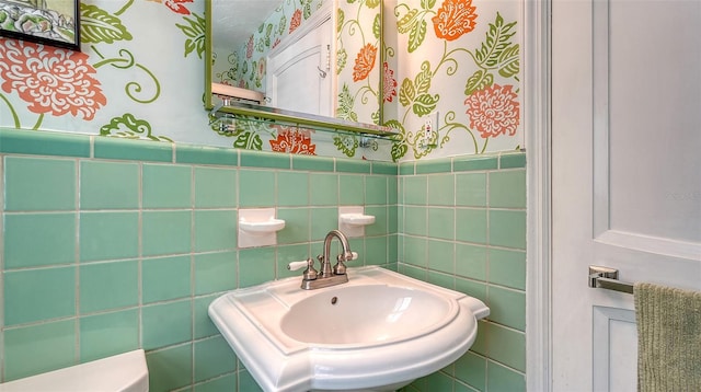 bathroom featuring sink and tile walls