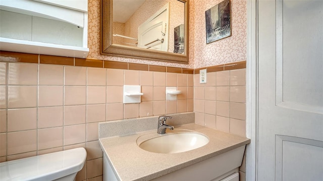 bathroom with vanity, tile walls, and toilet