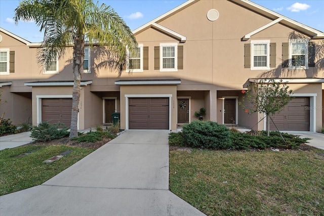 townhome / multi-family property with a garage and a front yard