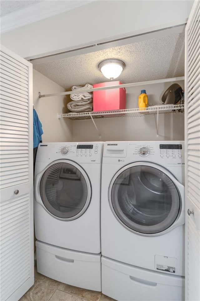 washroom with independent washer and dryer and a textured ceiling