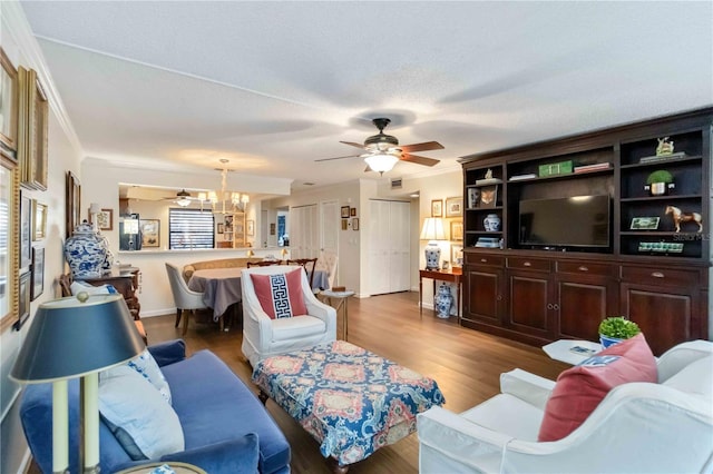 living room with ornamental molding, ceiling fan, and light hardwood / wood-style floors