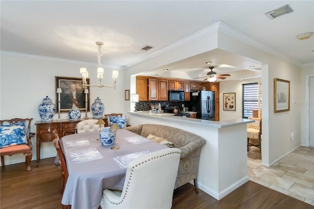 dining space featuring crown molding, ceiling fan with notable chandelier, and light hardwood / wood-style flooring