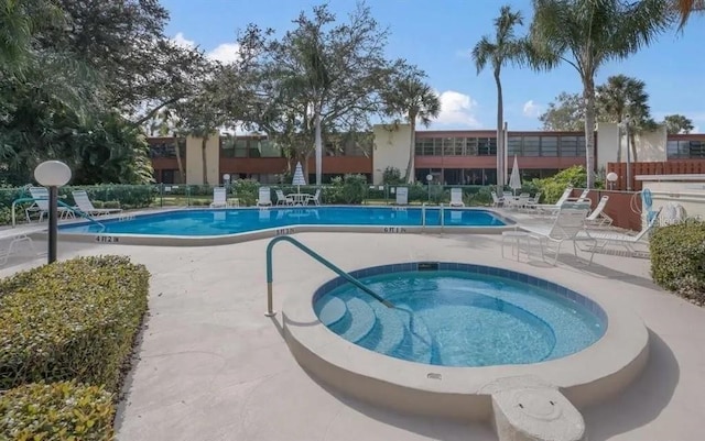 view of swimming pool featuring a community hot tub and a patio area