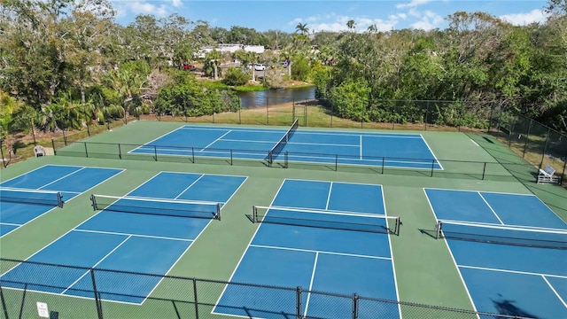 view of tennis court with a water view