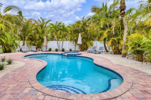 view of swimming pool featuring a patio area and an in ground hot tub