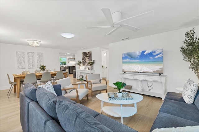 living room with ceiling fan and light hardwood / wood-style floors