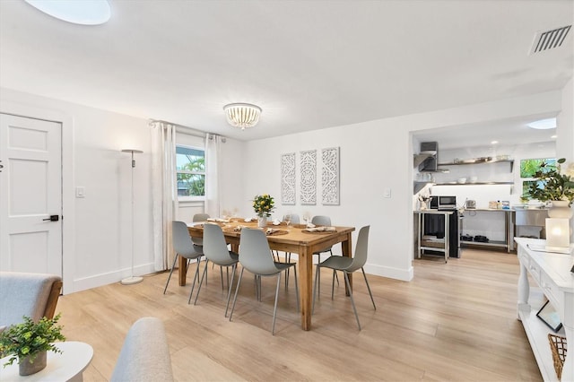 dining space with a chandelier and light hardwood / wood-style flooring