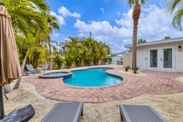 view of swimming pool with an in ground hot tub, a patio area, and french doors