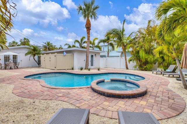 view of swimming pool featuring an in ground hot tub and a patio