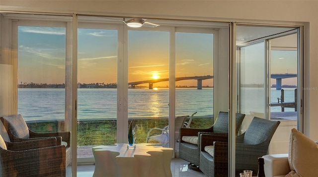 sunroom featuring a water view