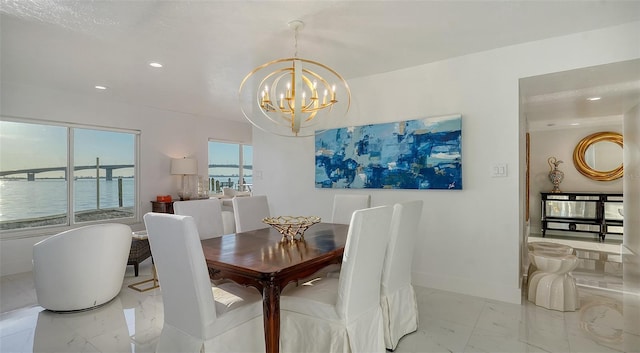 dining area with a chandelier and a water view