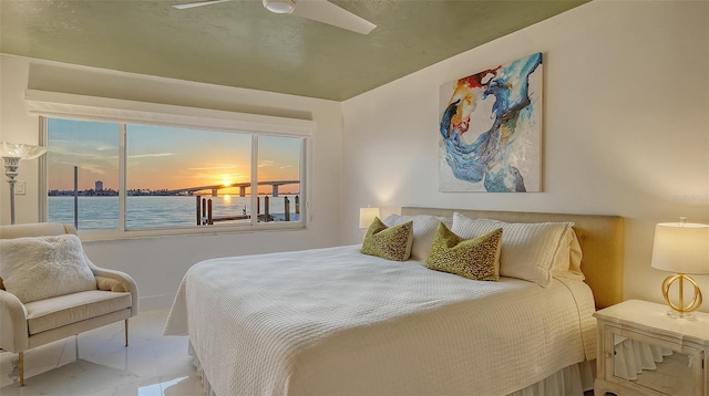 bedroom featuring a water view and ceiling fan