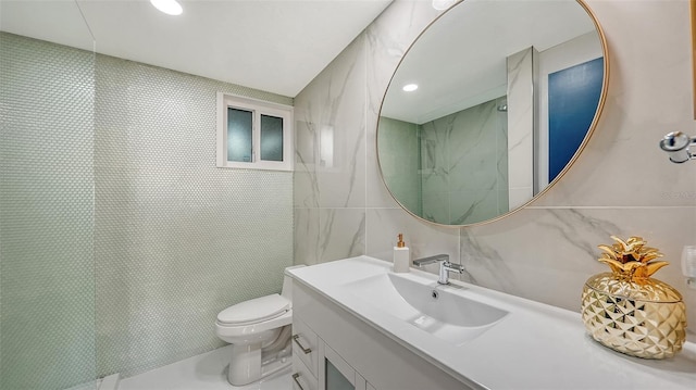 bathroom with vanity, tile walls, and toilet