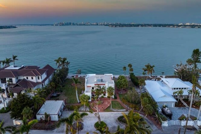 aerial view at dusk featuring a water view