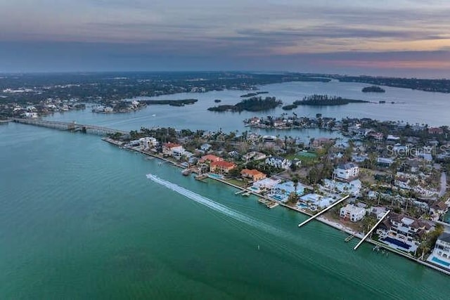 aerial view at dusk featuring a water view