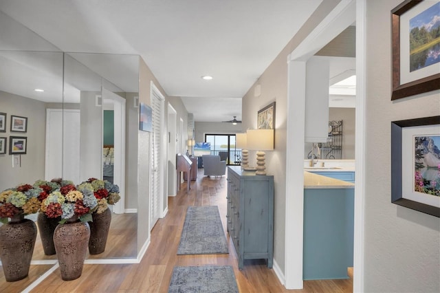 corridor with hardwood / wood-style flooring and sink